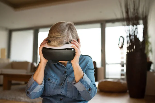 Mujer mayor con gafas de realidad virtual en casa — Foto de Stock