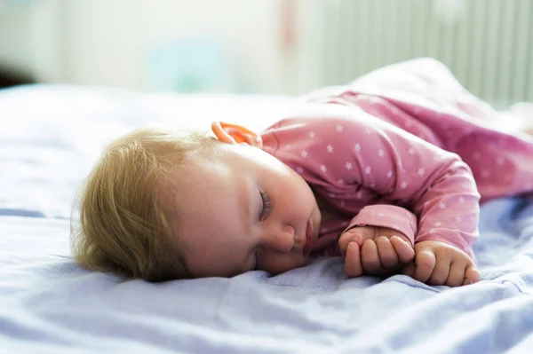 Schattig klein babymeisje thuis op bed liggen, slapen — Stockfoto