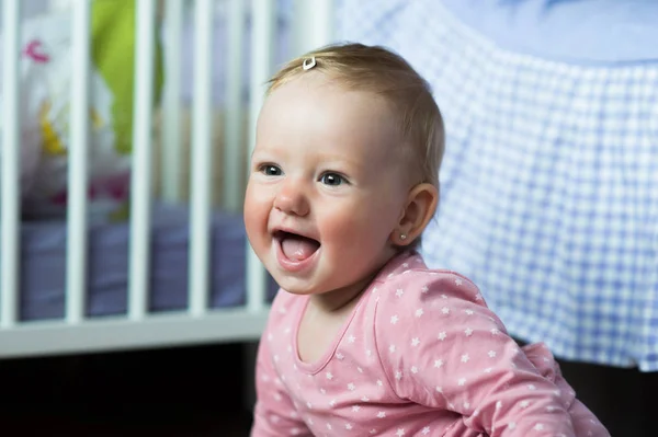 Bambina in abito rosa a casa seduta sul pavimento, sorridente — Foto Stock