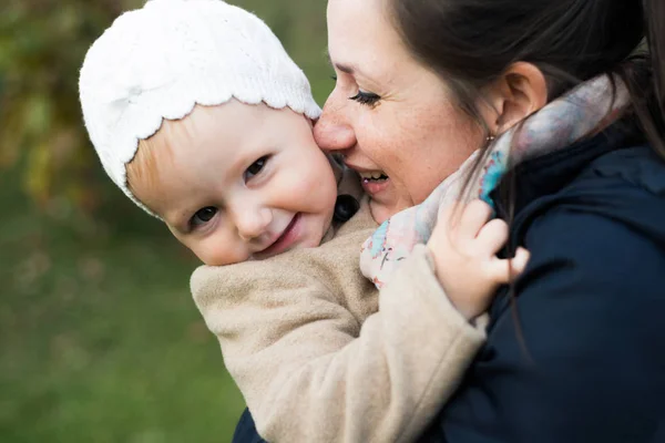 Beautiful mother carrying her daughter in her arms. Green nature — Stock Photo, Image