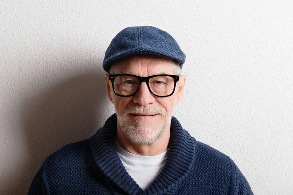 Uomo anziano in maglione e berretto, ripresa in studio . — Foto Stock
