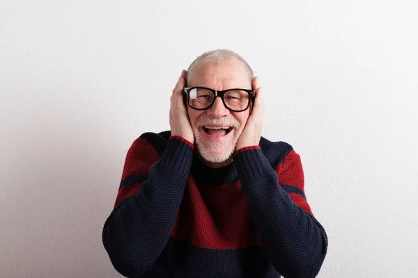 Happy senior man in red and blue sweater, studio shot. — Stock Photo, Image