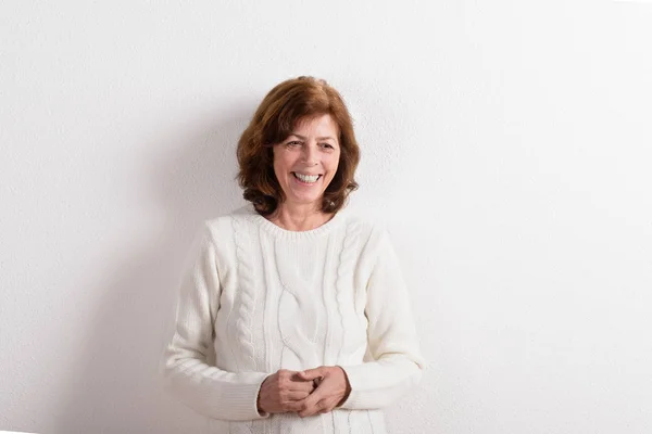 Senior woman in white woolen sweater, studio shot. — Stock Photo, Image