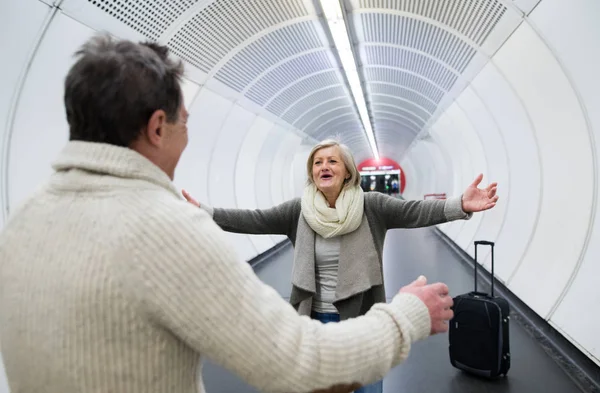 Senior couple in hallway of subway greeting — Stock Photo, Image