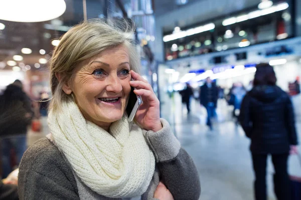 Seniorin mit Smartphone im Flur der U-Bahn — Stockfoto