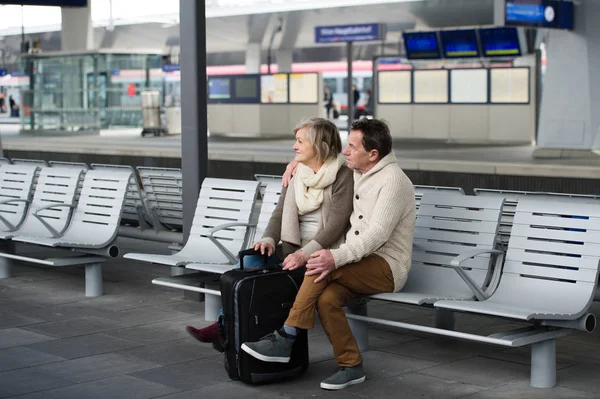 Couple de personnes âgées attendant à la gare, regardant la montre . — Photo
