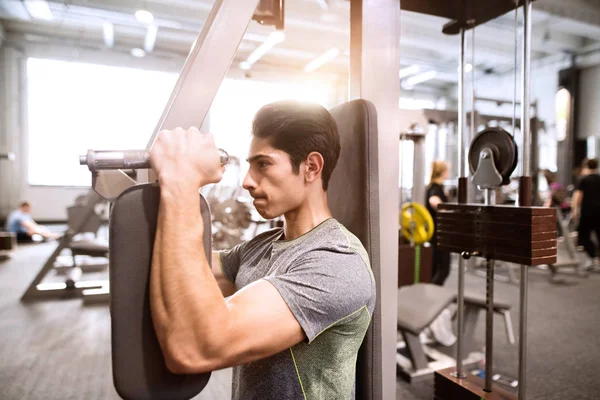 Spansktalande mannen i gymmet sitter på bänken, träna med vikter — Stockfoto