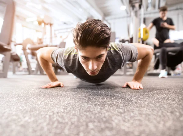 Mladí přizpůsobit hispánský muž v tělocvičně dělá push up — Stock fotografie