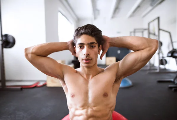 ジムのトレーニング、腹筋、クランチを行う作業にぴったりのヒスパニック系男性 — ストック写真