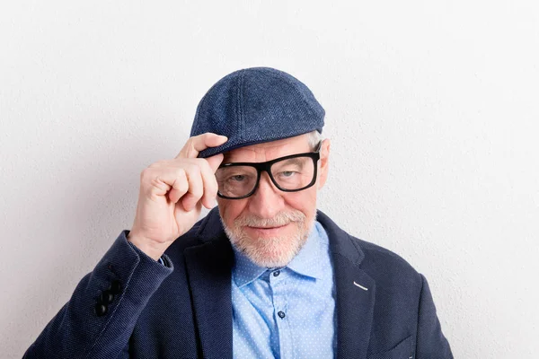 Uomo anziano in camicia blu, giacca, occhiali e cappello, studio sho — Foto Stock