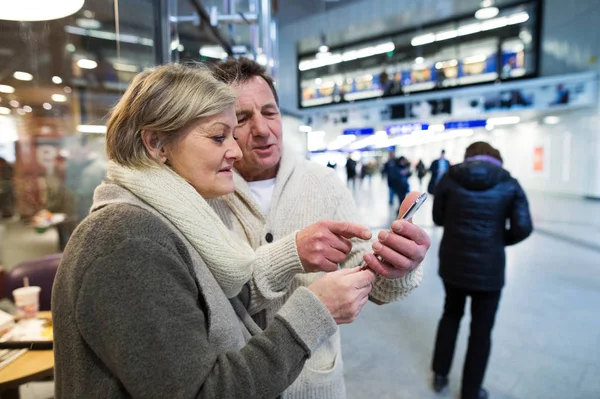 Starší pár s smartphone v chodbě metra — Stock fotografie