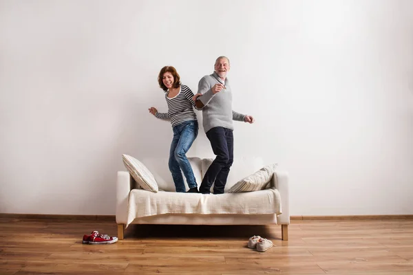 Bella coppia anziana in piedi sul divano, a ballare. Studio girato . — Foto Stock