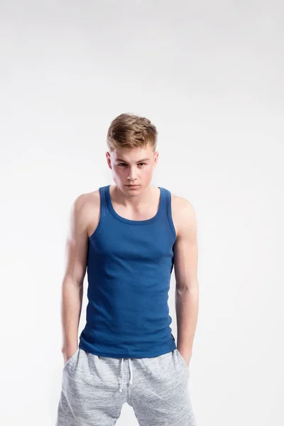 Bello fitness uomo in camicia blu canotta, ripresa in studio . — Foto Stock
