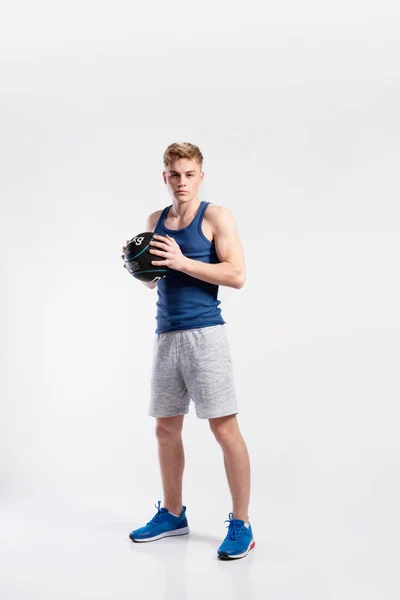 Knappe fitness man met Medicijnbal, studio opname. — Stockfoto