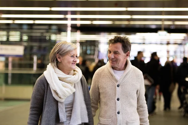 Pareja mayor caminando en el pasillo del metro, tomados de la mano . —  Fotos de Stock