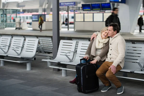 Senior couple waiting on train station, sitting on bench. — Stock Photo, Image