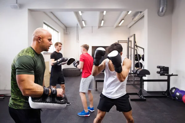 Fit homme hispanique dans la boxe de gymnase avec son entraîneur . — Photo