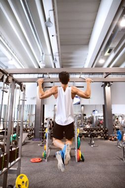 İspanyol adam pull-up yatay çubuk üzerinde yapıyor spor salonunda.