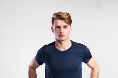 Genç yakışıklı hipster adam mavi t-shirt, stüdyo vurdu içinde.