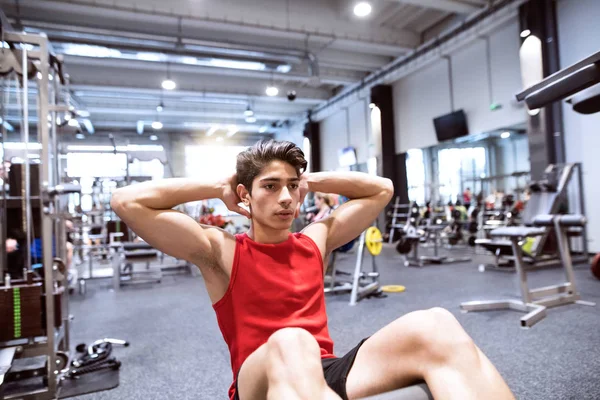 Passar spansktalande mannen i gymträning, arbetar abs, gör crunches — Stockfoto