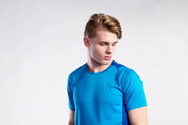 Junger gutaussehender Hipster-Mann in blauem Sport-T-Shirt, Studioaufnahme. — Stockfoto