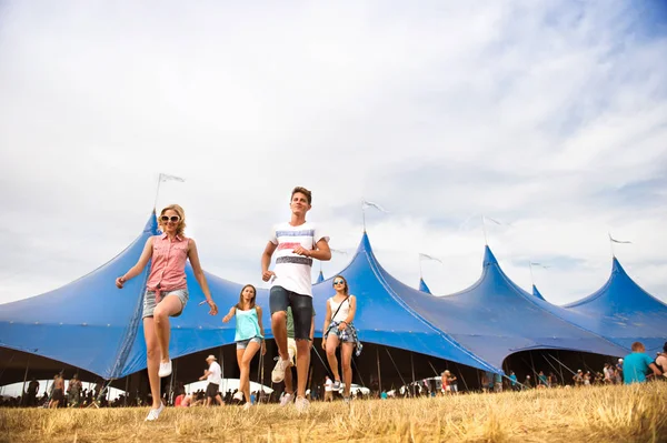 Tonåringar på summer music festival framför stora blå tält — Stockfoto