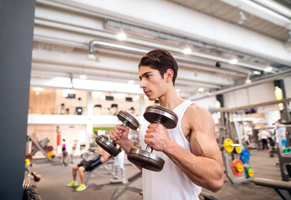 Ajuste hombre hispano en el gimnasio haciendo ejercicio con pesas —  Fotos de Stock