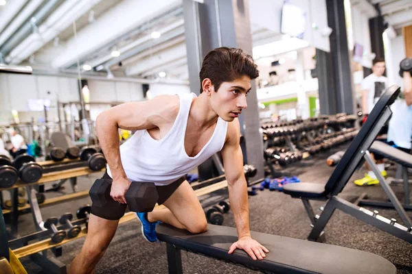 Homme hispanique dans la salle de gym sur banc, travailler avec des poids — Photo