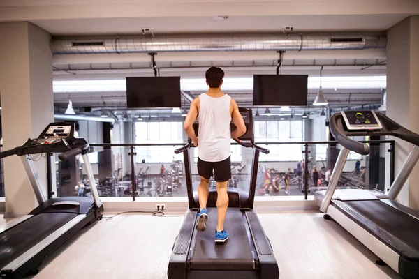 Giovane in forma ispanico uomo in palestra in esecuzione sul tapis roulant . — Foto Stock