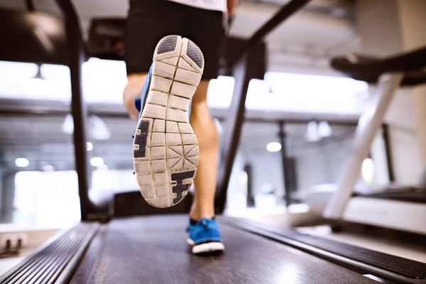 Oigenkännlig passar spansktalande mannen i gymmet kör på löpband. — Stockfoto