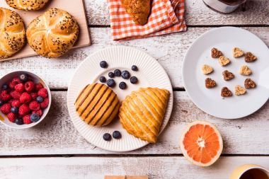 Kahvaltı yemek beyaz ahşap masanın üzerine koydu. Stüdyo vurdu.