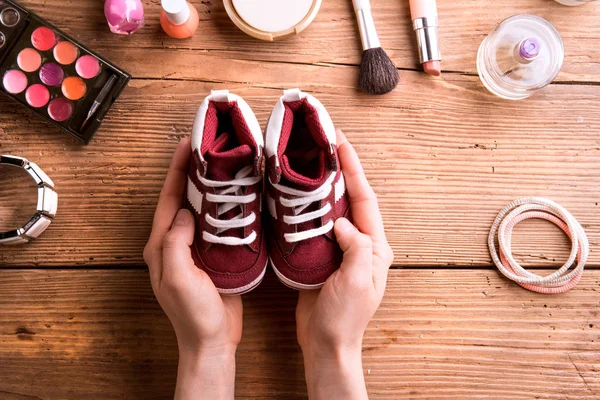 Muttertagszusammensetzung. kleine Schuhe und Schönheitsprodukte. — Stockfoto