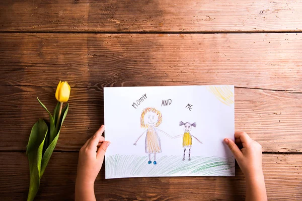 Fille tenant le dessin de sa mère. Tulipe jaune. Plan studio . — Photo