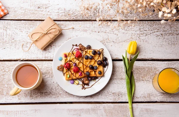 Frühstück, Geschenk und Blume. Studioaufnahme, Holzhintergrund. — Stockfoto