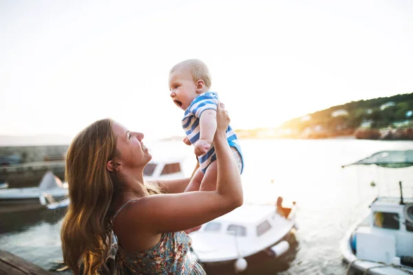 Hübsche Frau mit Baby-Sohn genießt ihre Zeit am Meer. — Stockfoto