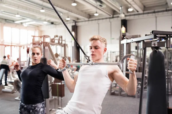 Fitter junger Mann trainiert im Fitnessstudio auf Abzugsgerät. — Stockfoto