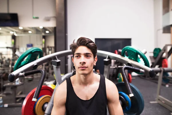 Spansktalande mannen i gym förberedd för utbildning på fitness maskin. — Stockfoto