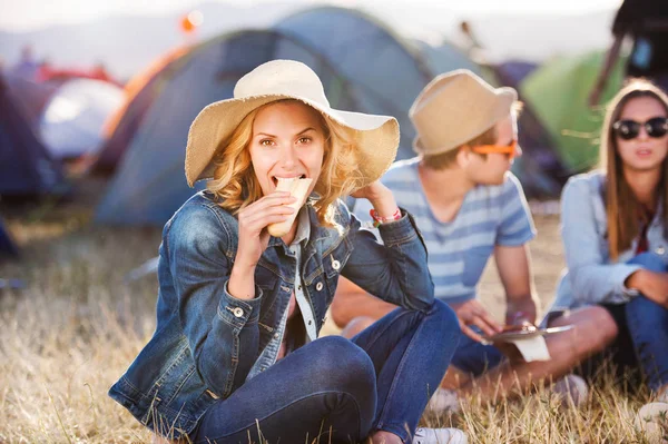 Tieners zittend op de grond voor tenten en eten — Stockfoto