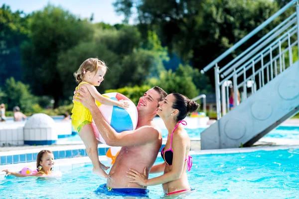 妈妈，爸爸和女儿在游泳池里。阳光灿烂的夏天. — 图库照片
