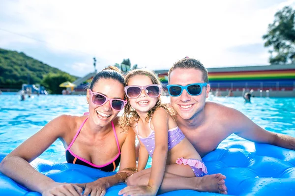 Moeder, vader en dochter in zwembad. Zonnige zomer. — Stockfoto