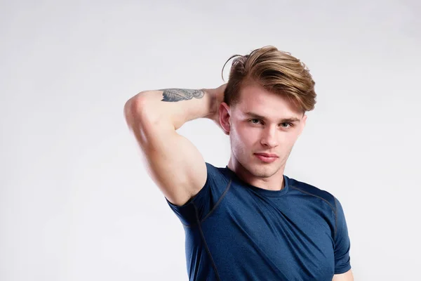 Young handsome hipster man in blue t-shirt, studio shot. — Stock Photo, Image