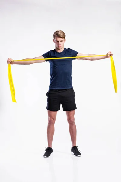 Fitness man arbetar med resistance band, studio skott. — Stockfoto