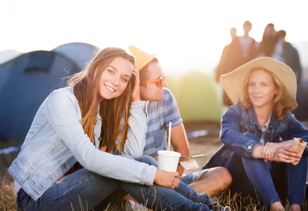 Adolescenti seduti a terra davanti alle tende, a riposo — Foto Stock