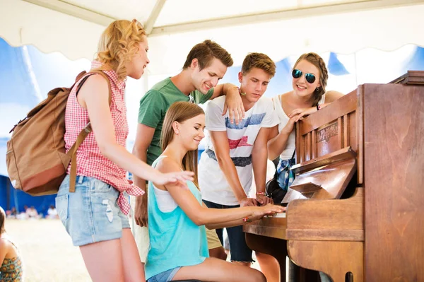 Подростки на летнем музыкальном фестивале, девушка играет на пианино — стоковое фото