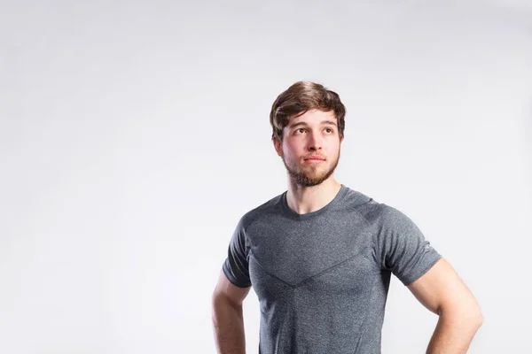Knappe fitness man in grijs t-shirt, studio opname. — Stockfoto