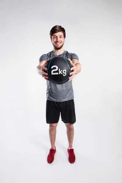 Knappe fitness man met Medicijnbal, studio opname. — Stockfoto