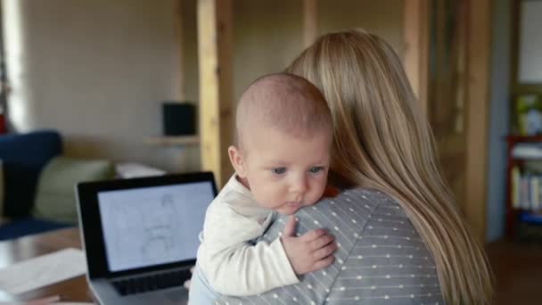 Mãe irreconhecível com filho nos braços, trabalhando no laptop — Vídeo de Stock