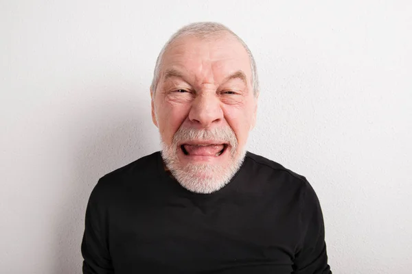 Senior Mann macht lustiges Gesicht, Studioaufnahme. — Stockfoto