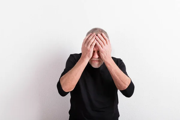 Hombre mayor trastornado con dolor de cabeza, sosteniendo su cabeza, plano de estudio . — Foto de Stock