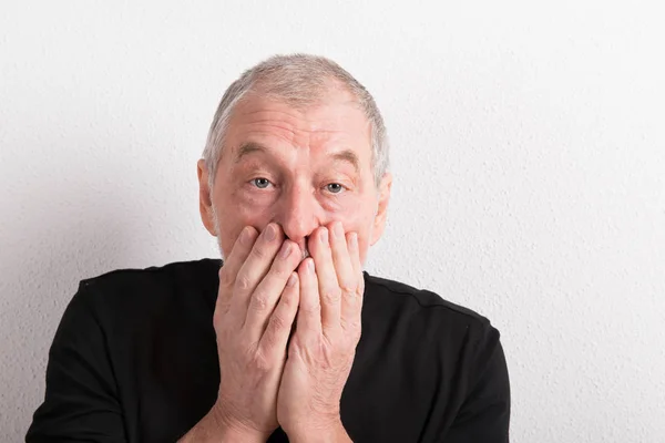 Upset senior man with headache, holding his mouth, studio shot. — Stock Photo, Image